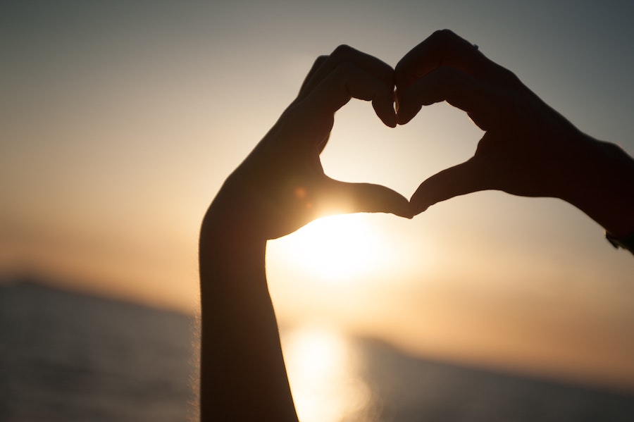 Hände formen Herz vor Himmel symbolisieren emotionale Kundenbindung